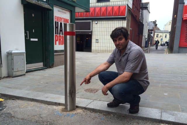Tony Vettese pointing to one of the bollards on Back Crescent Street which a driver squeezed past damaging it.