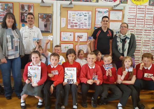 Tracy and Michl Kohl from West End Impact and Emma Hamilton, with Chris Beckett and pupils from Trumacar Primary School with their contribution to a special colouring book to inspire Team GB athletes.