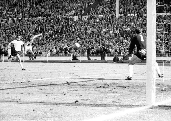 England's Geoff Hurst cracks a shot past German goalkeeper Hans Tilkowski to score the final goal of the World Cup Final against West Germany at Wembley
