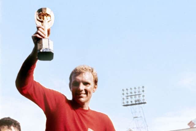 England captain Bobby Moore displays the World Cup trophy whilst being carried by his England colleagues after their 4-2 win against West Germany.