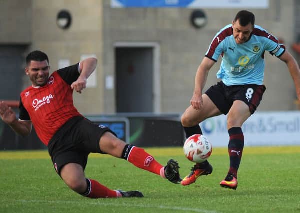 Alex Kenyon battles for the ball with Burnley's Dean Marney.