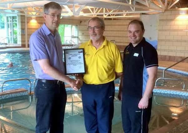 Michael Holgate (left) presents a long service award to retiring gym club manager David Oates. On the right is incoming manager Paul Tracey.
