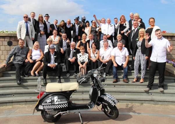 The wedding party of Steven and Jacqui Simpson celebrate by the Eric Morecambe Statue. Guests wore black and white because of Simmy's love of ska music. Photo by Mike Jackson.