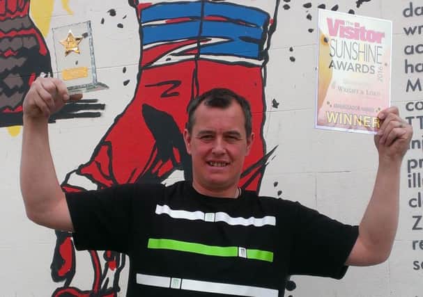 John McGuinness with the Sunshine Ambassador Award and the new mural in Morecambe paying tribute to his motorcycling achievements.