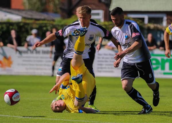 Simon Wills in the thick of the action for Lancaster City at Bamber Bridge. Picture: Paul Vause