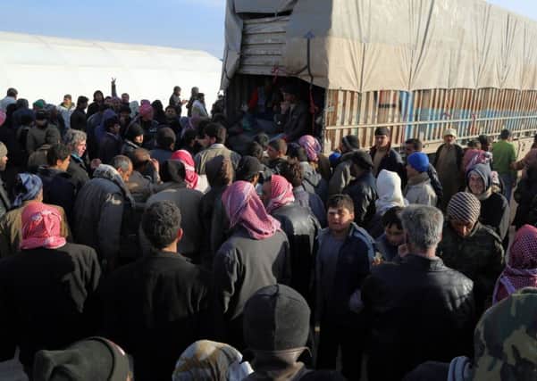 In this photo provided by Turkey's Islamic aid group of IHH, Syrians fleeing the conflicts.