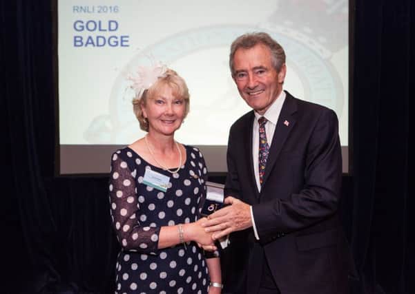 Mrs Lesley Waite receives her gold award from RNLI chairman Charles Hunter-Pease.