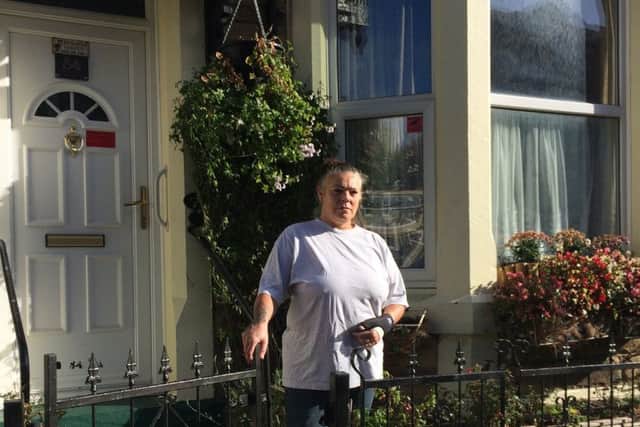 Lesley Cain outside her house on Albert Road which overlooks an occupied row of houses.