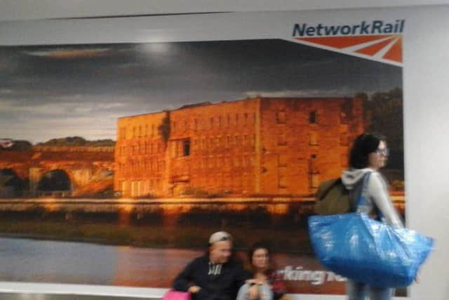The Network Rail poster showing the St George's Works mill as part of Lancaster Heritage City at Euston Station in London.