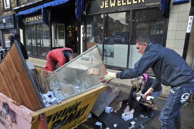Aftermath of the unprecedented flooding over the weekend in Lancaster.
Members of the Gregg family fill a skip with the ruined contents of their business, Cunningham Jewellers on Chapel Street.  PIC BY ROB LOCK
7-12-2015