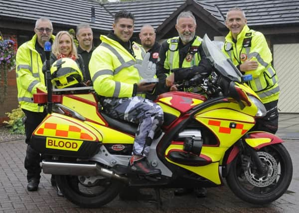 TV presenter Rav Wilding with members of North West Blood Bikes who have been given a National Lottery award.  He is pictured on the bike with members L-R Graham Miller, Amanda Mason, Colm Carton, James Robinson, Paul Brooks and Lee Townsend.