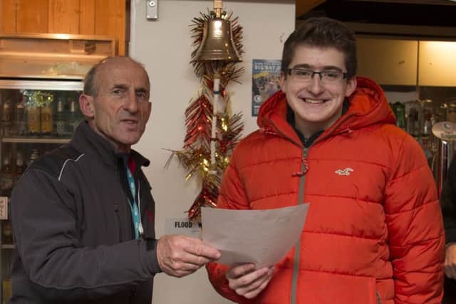 Adam Leech, from Scotforth, receives the award for winning the swimming race from MSC commodore, John Gibbison.