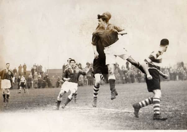 Playing for Morecambe in 1955 Ray Charnley leaps for a high cross watched by Ron.