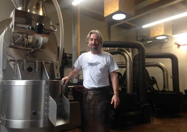 Ian Steel with the new coffee roaster and the older, more traditional ones in the background