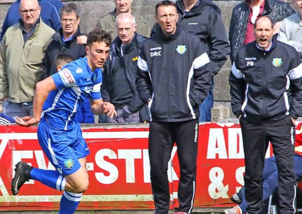 Phil Brown, right, and Dave McCann look on as Josh Earl breaks down the wing against Kendal. Picture: Tony North