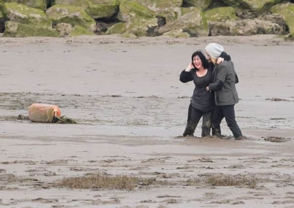 A woman is rescued from the mud in Morecambe. Picture: @ArtDecoCoast.