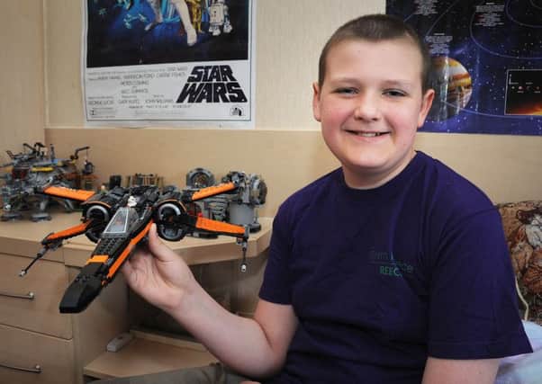 Reece Holt, of Church Park in Overton, is nearing the end of a gruelling course of chemotherapy following his brain tumour diagnosis last year.
Star Wars fanatic Reece with a model X-Wing fighter.  PIC BY ROB LOCK
10-4-2017