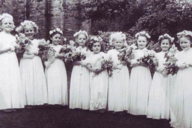 Taken from Ann Burgess's collection of St Joseph's Catholic Primary School in Lancaster. This picture shows children gathering for the May procession at the school. Ann Burgess is pictured at the very end on the right. Second from right is Yvonne Riley, Joan McCloughlian, Eileen Makison, Pat Hallam, Doreen Omerod, Alma Regan, Winnie Kelly and Margaret Prickett (who went on to become a nun).