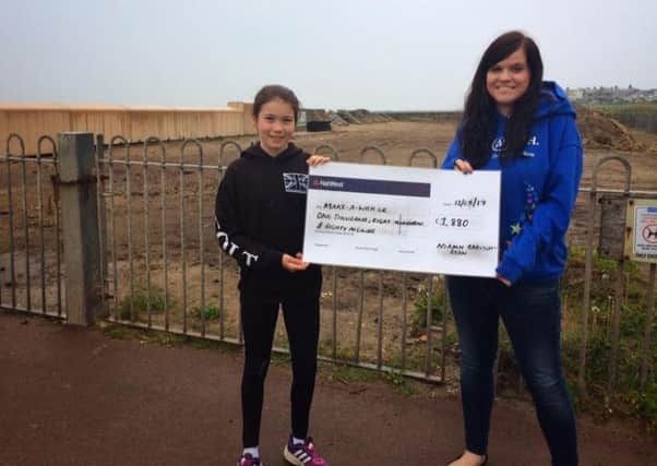 Niamh Barnsley-Ryan handed a cheque of Â£1,800 to Lucy Leeming, of Make-A-Wish Foundation, outside the Bay Cottage Play Area in Heysham.