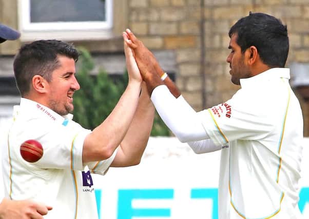 Ben Simm congratulates Kasun Madushanka on one of his four wickets against Blackpool. Picture: Tony North