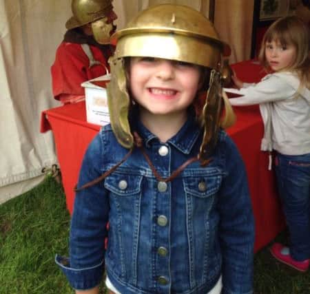 Zoe, aged 5, tries on a Roman helmet in Bitts Park