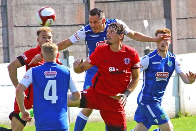 Glenn Steel wins a header as the Dolly Blues picked up another clean sheet.  Picture: Tony North