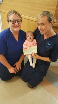 Nurses with Natalies daughter Lyla-Jayne and the cheque.