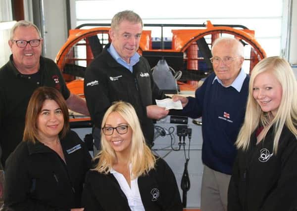 Glenn Harrison from VolkerStevin and colleagues present a cheque to RNLI fundraiser Raymond Hurst.