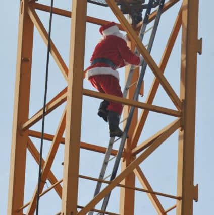 MORECAMBE  18-12-17 Cihan Oktem director and project manager, dressed as Santa, climbs the hugh crane on Stainton Bespoke Homes development, The Broadway, Morecambe, which are due to be finished January 2019.