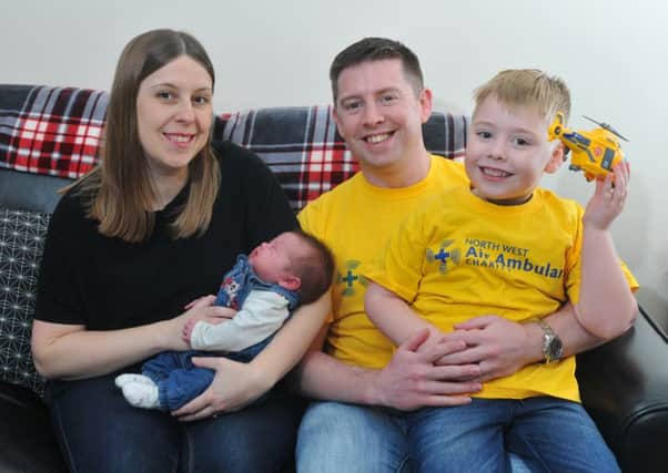 Photo Neil Cross David Lambert and five-year-old son Christopher who did a sponsored swim for air ambulance six months after they saved David's life, with wife Claire and new baby Bethany