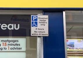 A sign set back from the road is the only indication the bay is for disabled drivers.
