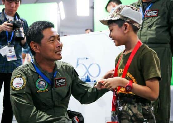 A child with a pilot from the Singapore air force.