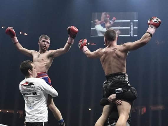 Isaac Lowe and Ryan Walsh are both lifted aloft after their draw at the Manchester Arena.
