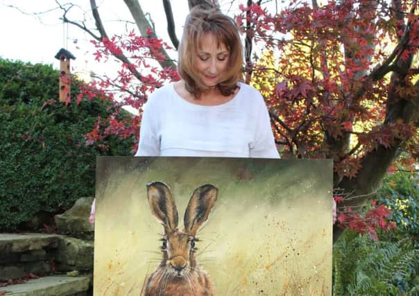 Artist Bree Meryn with one of her paintings.