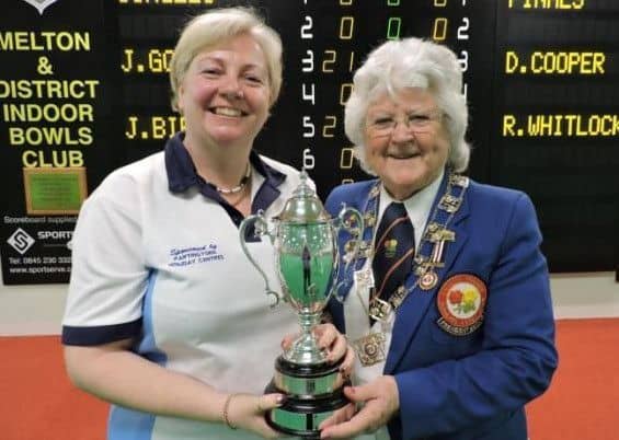 Janice Gower (left) receives the women's singles trophy from EIBA president Margaret Allen.