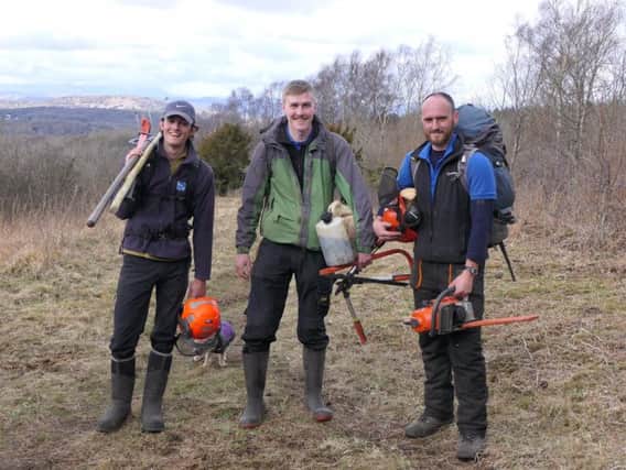 RSPB volunteers Cal Shipton and Connor Duhig with RSPB Estate Worker Richard Smith at work at Warton Crag nature reserve near Carnforth