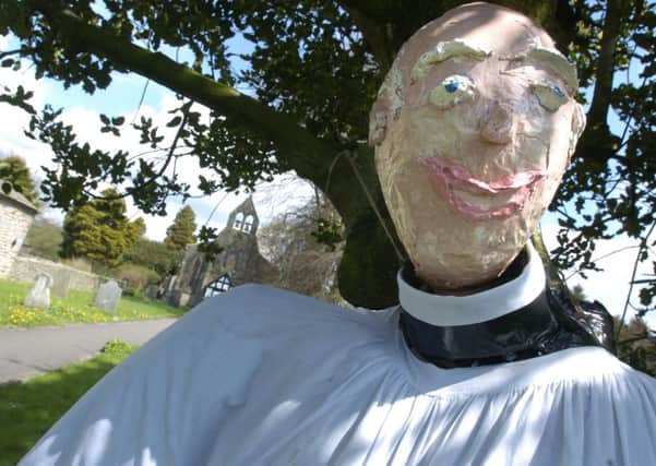 The scarecrow Vicar of Wray's Holy Trinity Church welcomes parishoners.