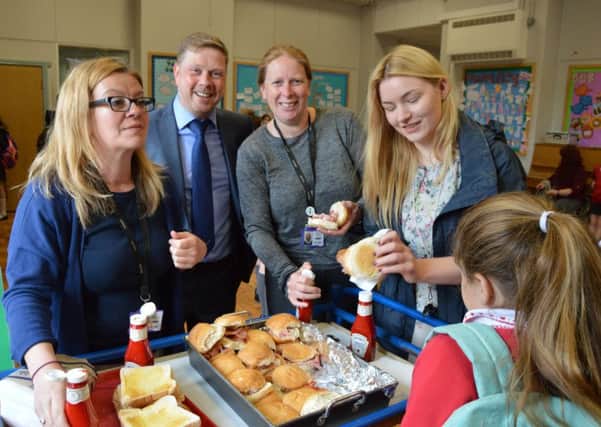 Darryl Rothwell, manager at Yess Electrical (second from left) with teachers and pupils at Sandylands Primary School on Friday bacon butties day, a new initiative sponsored by the business to help tackle child poverty.