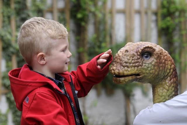 Dino-Day in Lancaster city centre.  4-year-old Billy Whitfield meets Brenda the Brontosauraus