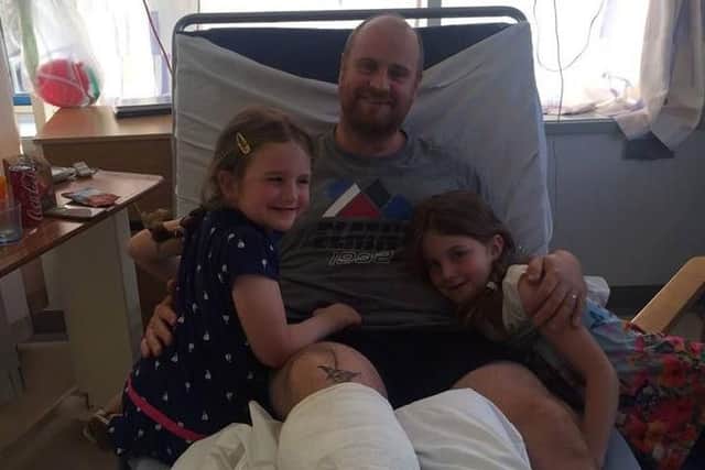 Andy in hospital with his daughters.